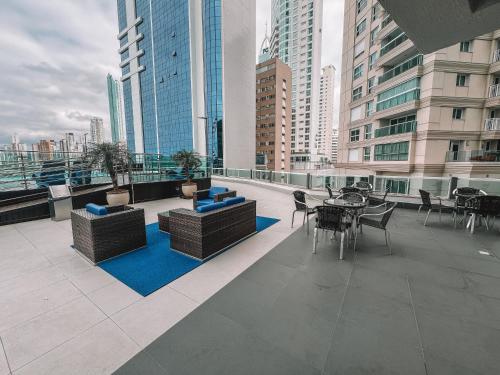 a balcony with tables and chairs on a building at Loft vista panorâmica da Roda gigante e orla de BC in Balneário Camboriú