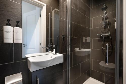 a bathroom with a white sink and a shower at Lake Road Apartments in Bowness-on-Windermere