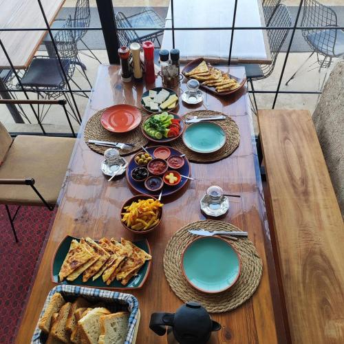 a wooden table with plates of food on it at DEEP CAVE House in Urgup