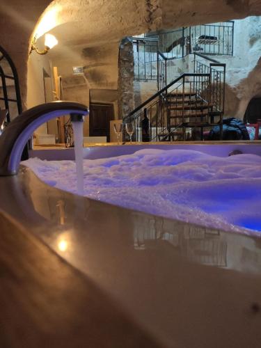 a hot tub with snow in a room with a staircase at DEEP CAVE House in Urgup