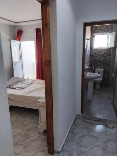 a bedroom with a bed and a sink and a mirror at Appart 1 Zarzis centre ville in Zarzis