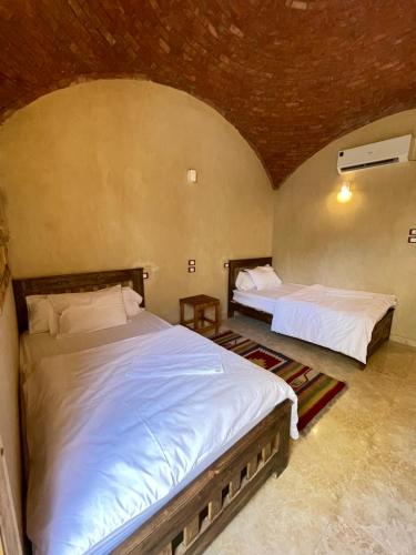 a bedroom with two beds in a room at فندق إريغن Erighin siwa hotel in Siwa