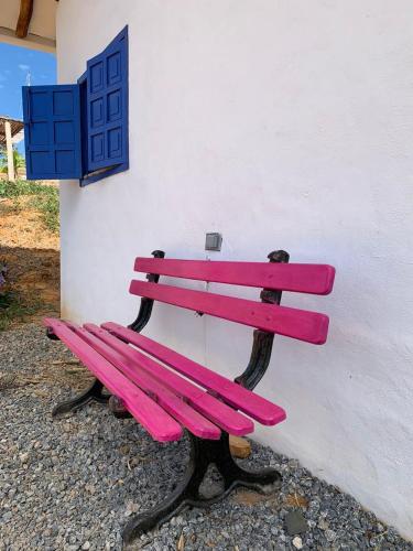 a pink bench sitting next to a white wall at Refugio en Barichara con piscina, jardines y atardeceres únicos in Barichara