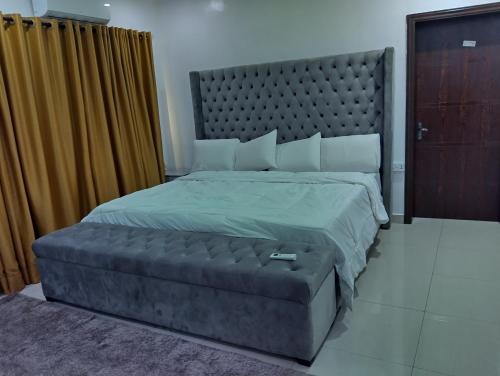 a bedroom with a large bed with a large headboard at Spacious Penthouse 1 Apartment in Lagos