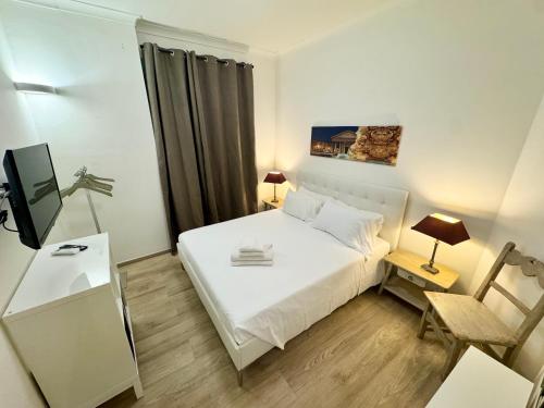 a small bedroom with a white bed and a tv at Mellini Escape in Rome