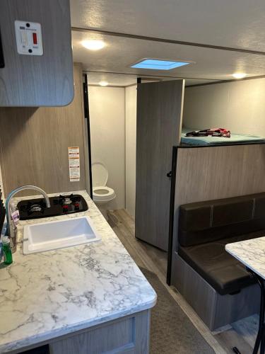 a kitchen with a sink and a toilet in it at Cozy Camper Retreat on Sleepy Hollow Lake in Athens