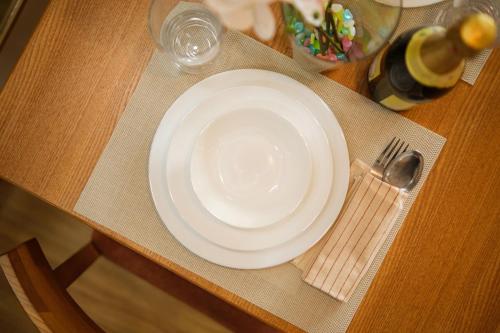 a white plate on a table with a fork and knife at Modern Rustic Home Staycation in Manila