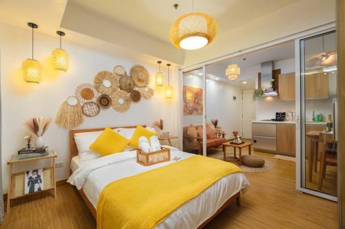 a bedroom with a yellow bed and a kitchen at Modern Rustic Home Staycation in Manila