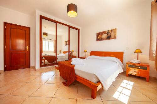 a bedroom with a large bed and a mirror at FF - Sea Breeze Guesthouse in Lagos