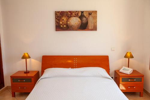 a bedroom with a bed with two nightstands and two lamps at FF - Sea Breeze Guesthouse in Lagos