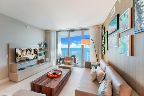 a living room with a couch and a table at LYFE Resort Ocean View Penthouse in Hollywood