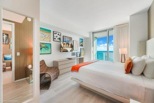 a bedroom with a bed and a desk and a window at LYFE Resort Ocean View Penthouse in Hollywood