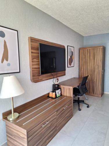 a room with a desk with a television and a chair at Quality Inn Piedras Negras in Piedras Negras
