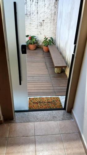 a door to a porch with a bench and plants at Edícula quarto suíte, confortável e bem localizado in Guaratinguetá
