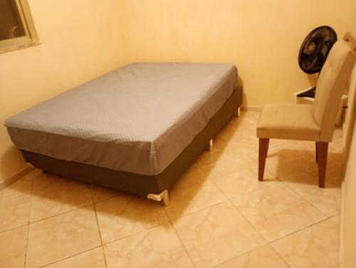 a bed and a chair in a room at Apartamento na zona oeste in Padre Miguel