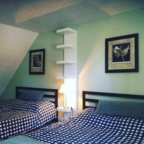 2 letti in una camera da letto con pareti verdi di Wasaga Beach Loft 4 a Wasaga Beach