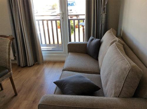 a living room with a couch and a sliding glass door at Discovery Bay in St Ouen's