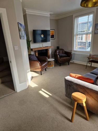 a living room with a couch and chairs and a tv at The Old Chemist - Viking Bay Getaway in Broadstairs
