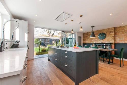 a kitchen with a large island in the middle at The Old School Hall - Opulence and Location in Kent