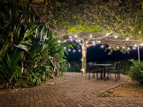 a table and chairs in a garden at night at Houttuyn Wellness River Resort in Paramaribo