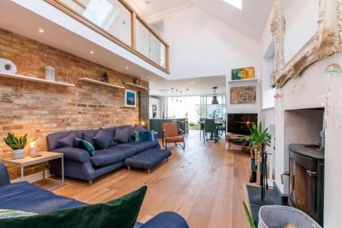 a living room with a couch and a brick wall at The Old School Hall - Opulence and Location in Kent