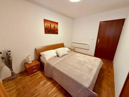 a bedroom with a bed and a wooden floor at Apartment in Dramalj 54763 in Dramalj