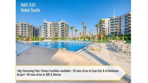 a picture of a swimming pool in front of some apartment buildings at Budget-friendly 2bd near EXPO with a huge pool in Dubai