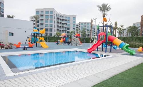 a playground with a swimming pool and a slide at Budget-friendly 2bd near EXPO with a huge pool in Dubai