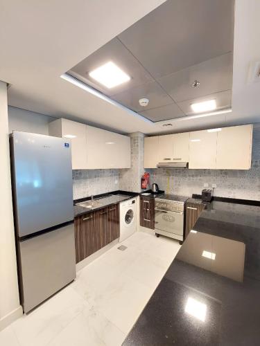 a kitchen with white appliances and a refrigerator at Budget-friendly 2bd near EXPO with a huge pool in Dubai