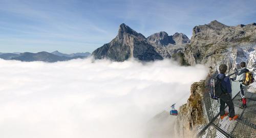 two people standing on top of a mountain above clouds at El Bodegon de Luis in Hinojedo