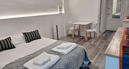 a bedroom with a bed with towels on it at Estudio Puna - Zona Aldrey - Guemes in Mar del Plata