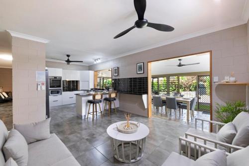 a living room and kitchen with a couch and a table at Nature's Nest - Pool - SPA - Outdoor Kitchen and Dining in Leanyer