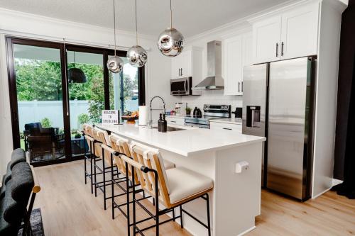 a kitchen with a large white island with bar stools at 3BR Chic Ybor City Tampa Firepit Bikes in Tampa