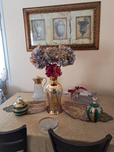 a table with a vase with flowers in it at Villa Excelsior in Kórinthos