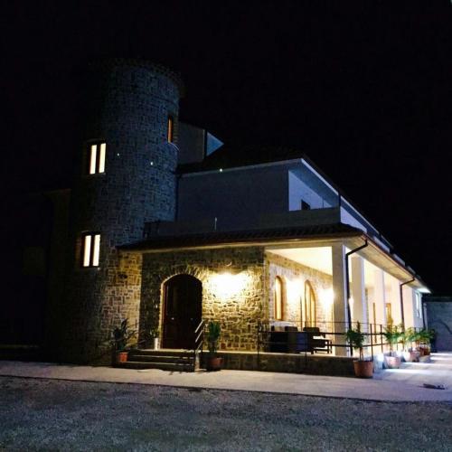 a large brick building with a tower at night at Golden House Cheravanna Da Marco in Castagneto