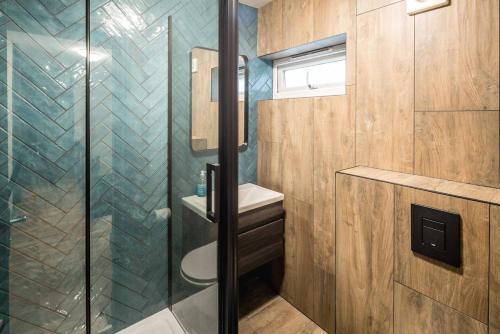a bathroom with a glass shower and a sink at 4BD Townhouse - Paddington! in London