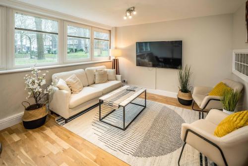 a living room with a couch and a tv at 4BD Townhouse - Paddington! in London