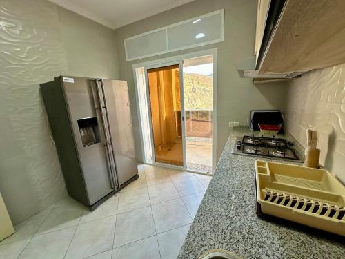 a kitchen with a stainless steel refrigerator and a counter at Apartamentos Alborj 7J إقامةالبرج in Ifargane