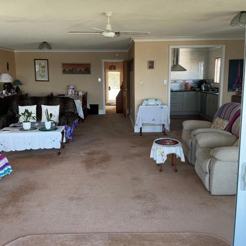 a living room with two tables and a couch at Tamaterau Seaview House in Whangarei in Whangarei