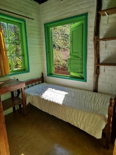 a bed sitting in a room with a window at Pousada Alquimia in Aiuruoca