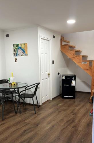 a dining room with a table and a staircase at Cabaña central a pasos del terminal in Valdivia