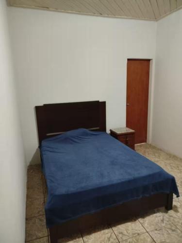 a bedroom with a bed with a blue blanket at Casa Completa para Festa do Peão de Barretos in Barretos