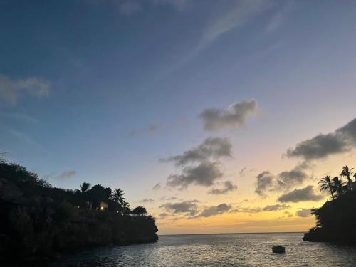 a sunset over the ocean with a boat in the water at Apartment "Always SUNday", Lagoon Ocean Resort in Lagun