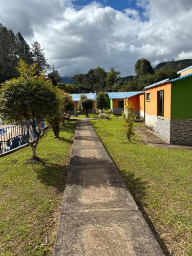 a concrete path in a yard with houses at Cabañas Gachalá - Centro vacacional El jazmín in Gachalá