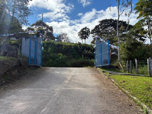an empty road with blue gates on the side at Cabañas Gachalá - Centro vacacional El jazmín in Gachalá