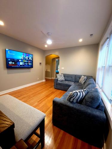 a living room with a couch and a flat screen tv at Beautiful 4 bedroom 2 bathroom apartment near everything in Chicago