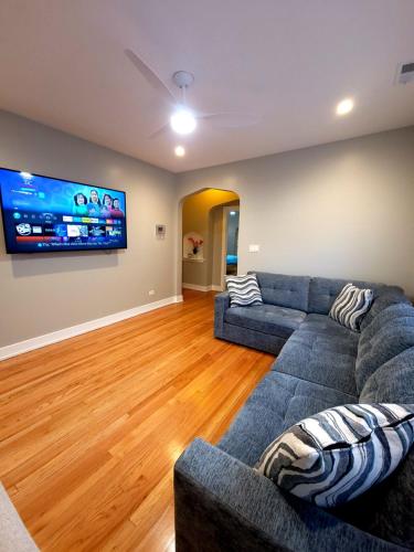 a living room with a couch and a flat screen tv at Beautiful 4 bedroom 2 bathroom apartment near everything in Chicago