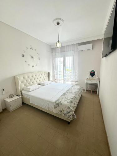 a bedroom with a large bed and a clock on the wall at Emanuela Dreams in Paleo Tsifliki