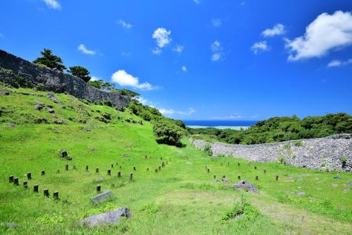 a group of people standing on a grassy hill at KIN Seaside Hills Town in Igei