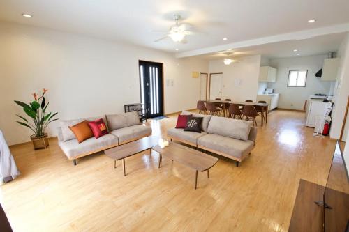 a living room with two couches and a dining room at KIN Seaside Hills Town in Igei